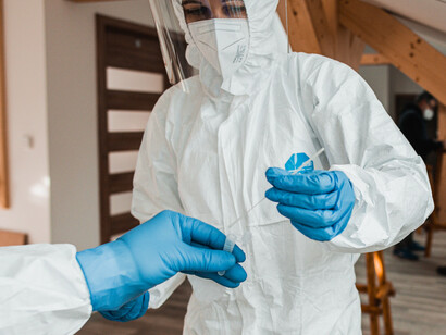 Personal sanitario protegido con equipos de protección individual durante la recogida de una muestra