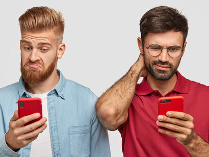 Two individuals expressing frustration while looking at their smartphone screens, portraying the detrimental effects of social media interactions
