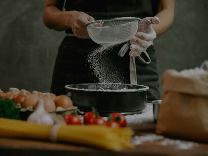 Cozinheira peneirando a farinha