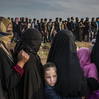 Abitanti di Mosul fanno la fila per ricevere cibo mentre sono in corso gli scontri per liberare la città dai miliziani del gruppo Stato islamico, 15 marzo 2017. The Battle for Mosul - Lined Up for an Aid Distribution © Ivor Prickett, for The New York Times