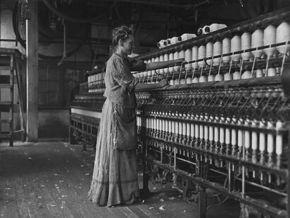 Woman operating a spinning machine in an early 1900s textile mill