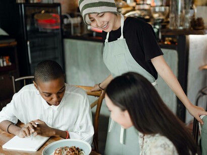 The waitress is charming the customers as a way to be hospitable in the restaurant