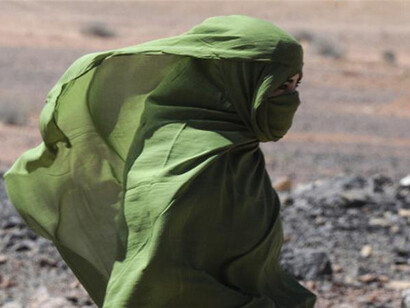 A Sahrawi woman walks in the desert near the Western Sahara village of Tifariti
