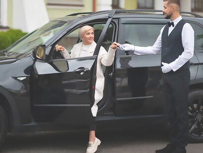 Enhance your VIP experience with luxury parking services as a valet expertly assists a client at exclusive events