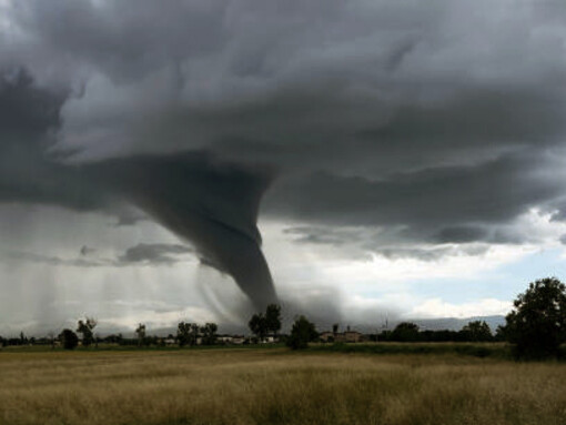 Storm chasers photograph a tornado beneath a dramatic supercell storm along a Montana dirt road, showcasing extreme weather events like hurricanes, USA