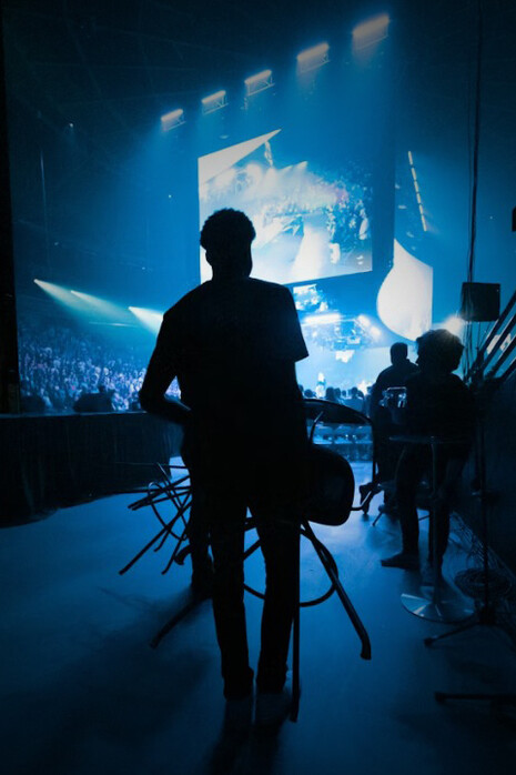 Silhouettes of musicians and crew during soundcheck at a concert venue