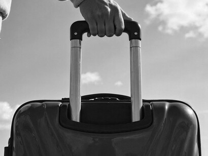 A suitcase against the sky isn’t just travel; it’s the physical manifestation of a broken homeland and a forced scattering