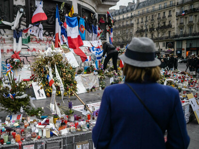 Una mujer observa los recuerdos a las víctimas en París