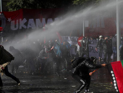 Demonstranten werden bei einer Kundgebung in Chile von einem Wasserwerfer getroffen