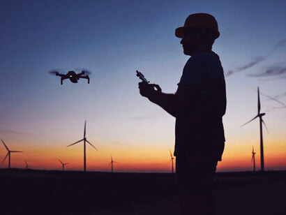 The silhouette of a soldier using a drone and a laptop for reconnaissance during a military operation