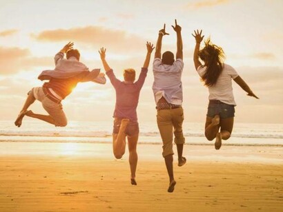 Un grupo de amigos saltando en la playa