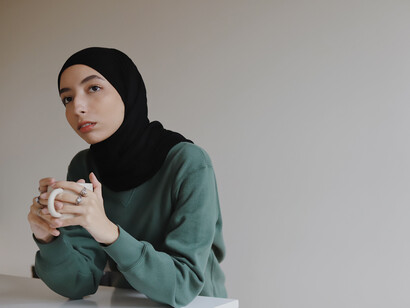 Mujer contemplativa sostiene una taza. El 'overthinking' es como viajar en el tiempo, pero en la peor de sus versiones, ya que pensar demasiado nos hace perdernos el presente