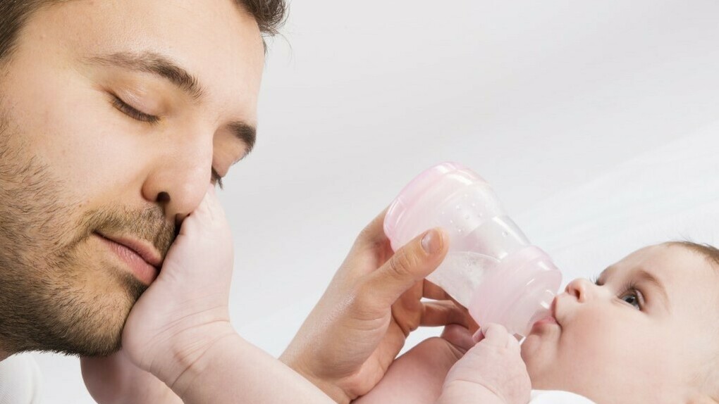 Un padre dando el biberón a su bebé