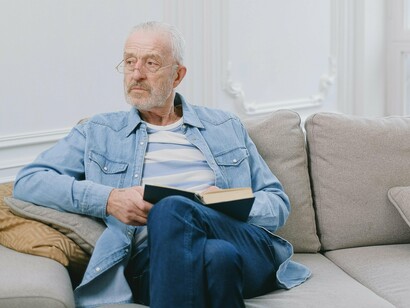 Homem relaxa lendo no sofá. O café, em pequenos goles pausados, provoca saborear um naco de chocolate, pão na chapa com manteiga de leite, ovos, queijo canastra vindo do interior de Minas Gerais - eis aí uma grande vantagem da internet: você vai na fonte, lá no interior de Minas, e traz queijo coalho de primeira grandeza