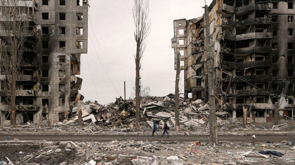 Personas caminan frenta a un edificio de apartamentos destruido durante los combates entre las fuerzas ucranianas y rusas en Borodyanka, Ucrania, el 5 de abril de 2022