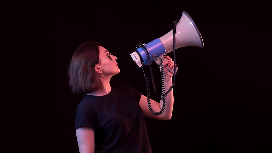 Young woman in black t-shirt holding megaphone