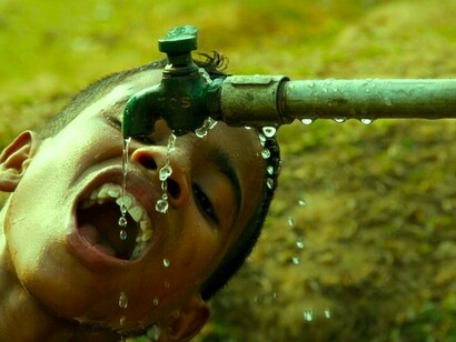 Un niño bebe en una fuente