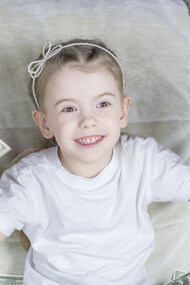 A little girl sitting on a couch holding money