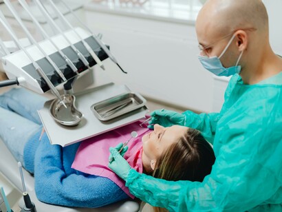 A woman undergoing a dental examination, illustrating the accessibility of advanced medical technology in developed countries