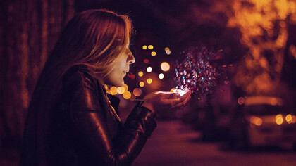 A girl blowing sprinkles into her hand, signifying magic