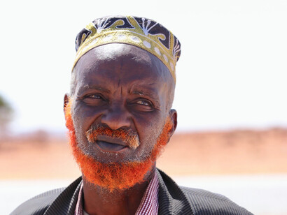 The orange henna on his beard signifies more than tradition, it represents a commitment to following the path of the Prophet Muhammad, whose teachings align with the values embedded in Somali proverbs