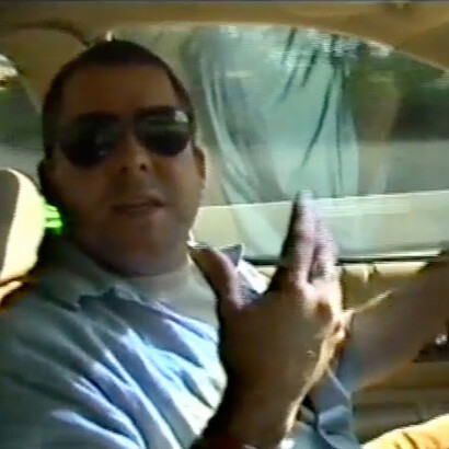Video still of Jason Rhoades interviewed by curator Hans Ulrich Obrist while driving the Caprice around Los Angeles, 1998.
© The Estate of Jason Rhoades. Courtesy of the Estate of Jason Rhoades and Hauser & Wirth