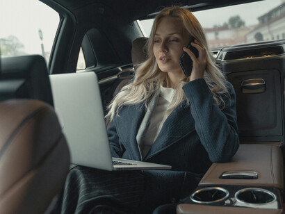 A business woman on a phone call inside a car