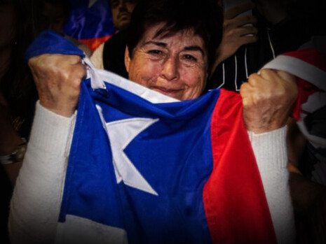 Mujer sostiene una bandera de Chile luego de conocer los resultados del Plebiscito Constitucional del pasado 4 de septiembre de 2022
