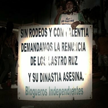 Manifestante en Miami, Estados Unidos, sostiene un cartel exigiendo la renuncia de los Castro Ruz durante las protestas en 2021