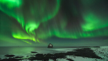Aurora boreal en las playas de Reynisdrangar