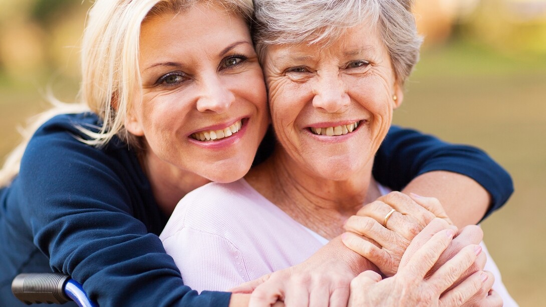 Una mujer abraza a su madre anciana