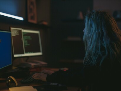 A software programmer operating several digital tools, symbolising the shift toward machine-mediated productivity