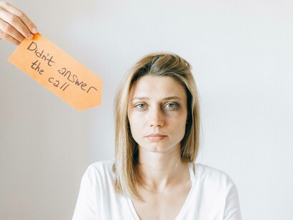 Woman looking sad with a sign explaining her feeling