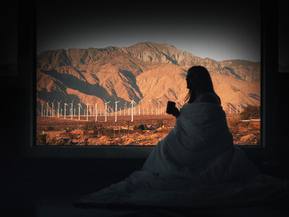 Mujer bebiendo café frente al amanecer en Palm Springs, California, EE.UU.