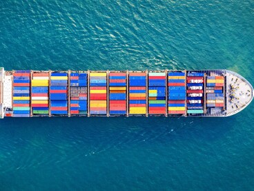 A cargo ship seen from above sailing the ocean, reflecting the movement of goods amid shifting economic conditions