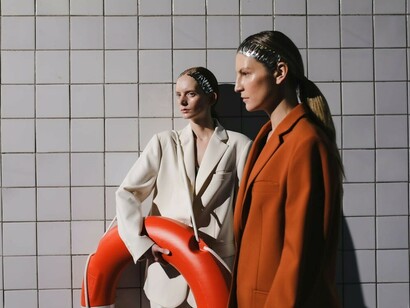 Models pose in oversized blazers and tailored suits, highlighting the appeal of oversized silhouettes while incorporating a lifebuoy for a striking, nautical-inspired touch