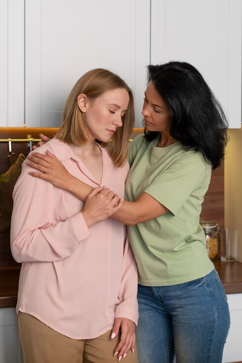 A woman experiencing a stomachache, highlighting the connection between the gut-brain axis and the potential benefits of probiotics, with her friend confronting her