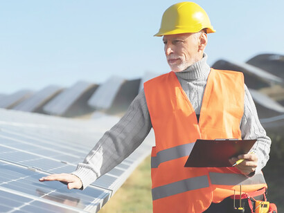 Individuals alongside alternative energy plants, featuring solar panels, emphasizing energy efficiency, renewable energy, and efforts to address climate change