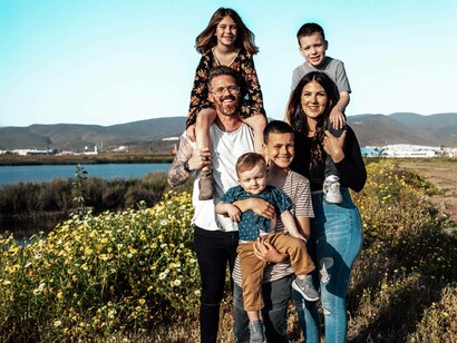 Mother and father and their four children taking a hike by the sea