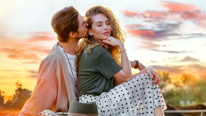 Casal heterosexual demostrando afeto ao pôr do sol