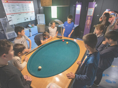 Sala María Sklodowska, en ella los visitantes pueden jugar al billar en una mesa elíptica y observar como las bolas se distribuyen en una figura parecida a una campana en el aparato de Galton