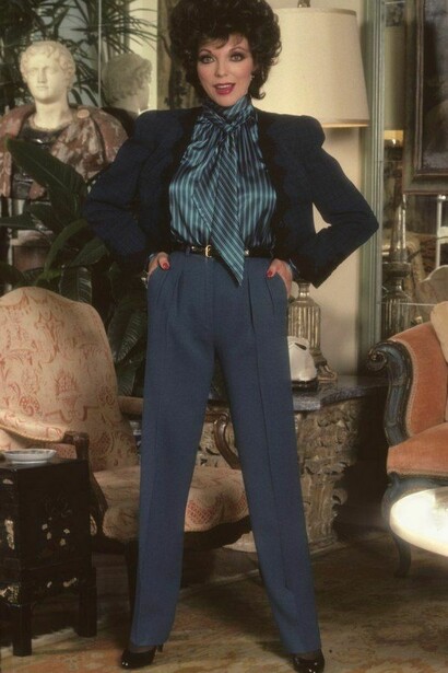 Joan Collins wearing dark blue power suit