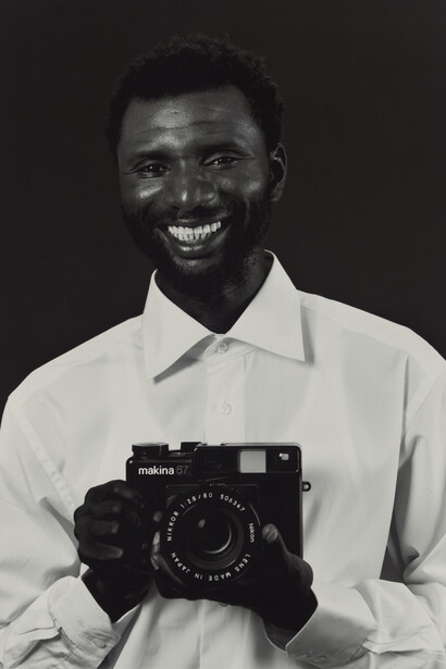 Christopher Williams, Mustafa Kinte (Gambia) / Camera: Makina 67 506347 / Plaubel Feinmechanik und Optik GmbH / Borsigallee 37 / 60388 Frankfurt am Main, Germany / Shirt: Van Laack Shirt Kent 64 / 41061 Mönchengladbach, Germany / Dirk Schaper Studio, Berlin / July 20, 2007. 2007. Gelatin silver print, paper: 20 × 16″ (50.8 × 40.6 cm); framed: 33 3/4 × 29 1/4″ (85.7 × 74.3 cm). The Art Institute of Chicago, restricted gift of Artworkers Retirement Society, 2013.1097. Courtesy of the artist; David Zwirner, New York/London; and Galerie Gisela Capitain, Cologne © Christopher Williams