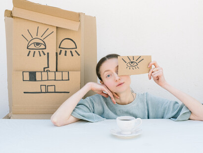 A woman covers her eye with a cardboard eye