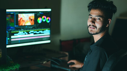 A man focused on editing content while working on his computer