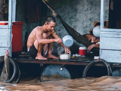 Men sit on a raised home due to flooding