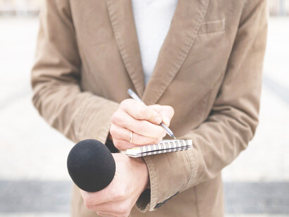 A close-up of a reporter preparing for an interview, highlighting themes of media censorship, press freedom, and the role of journalists