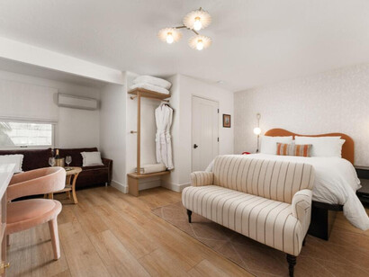 The room feels airy, calm, and inviting, with a soft neutral palette and subtle warm accents