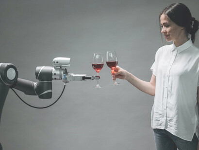A woman elegantly cradles a glass of fine wine while sharing a moment with an AI-driven robot