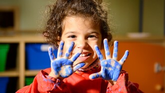 Niño con la manos manchadas de pintura